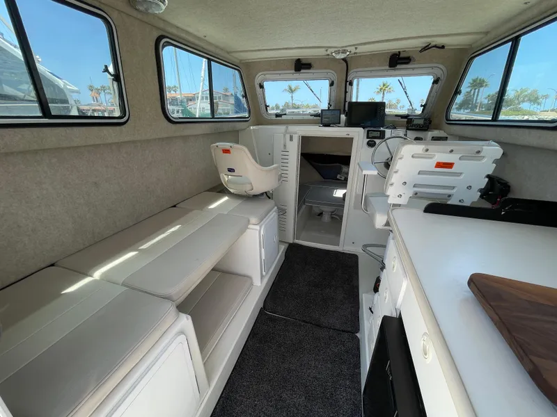 Slide: The Image of 2016 Parker 2530 Extended Sport Cabin interior with seating, helm, and windows. - 22