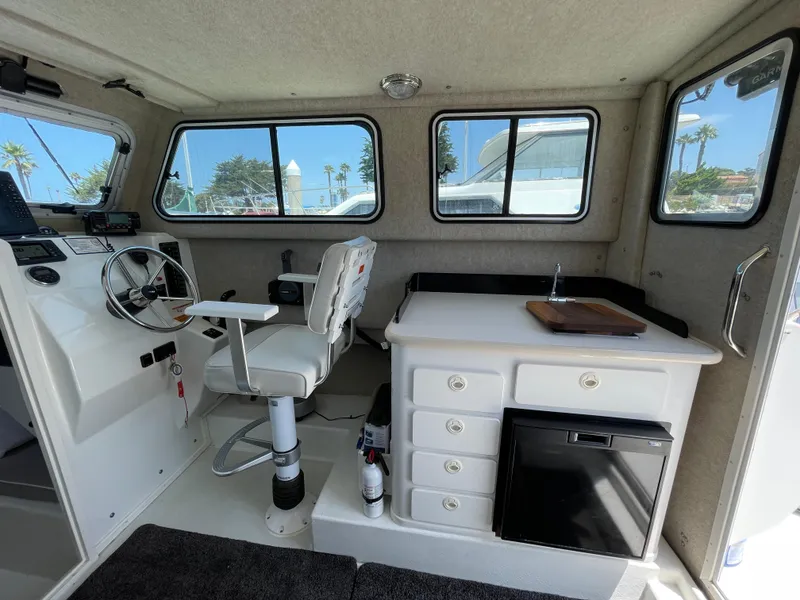 Slide: The Image of 2016 Parker 2530 Extended Sport Cabin interior with steering, kitchenette, and windows. - 23