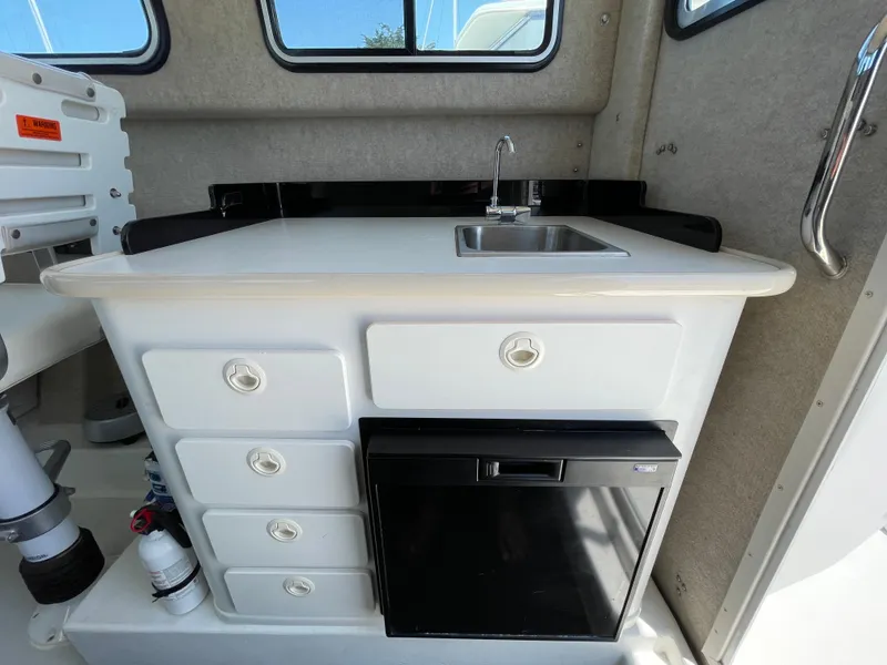 Slide: The Image of 2016 Parker 2530 Extended Sport Cabin interior with sink, drawers, and mini fridge. - 24