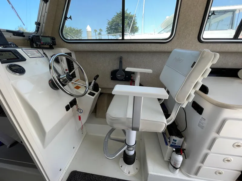 Slide: The Image of Interior of 2016 Parker 2530 Extended Sport Cabin with steering wheel and captain's chair. - 26