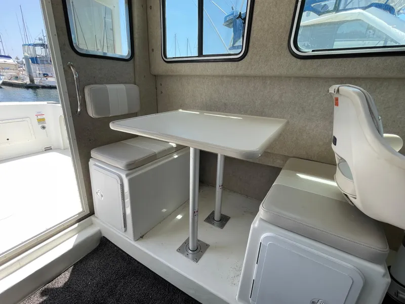 Slide: The Image of 2016 Parker 2530 Extended Sport Cabin interior with table and seating, docked at marina. - 34