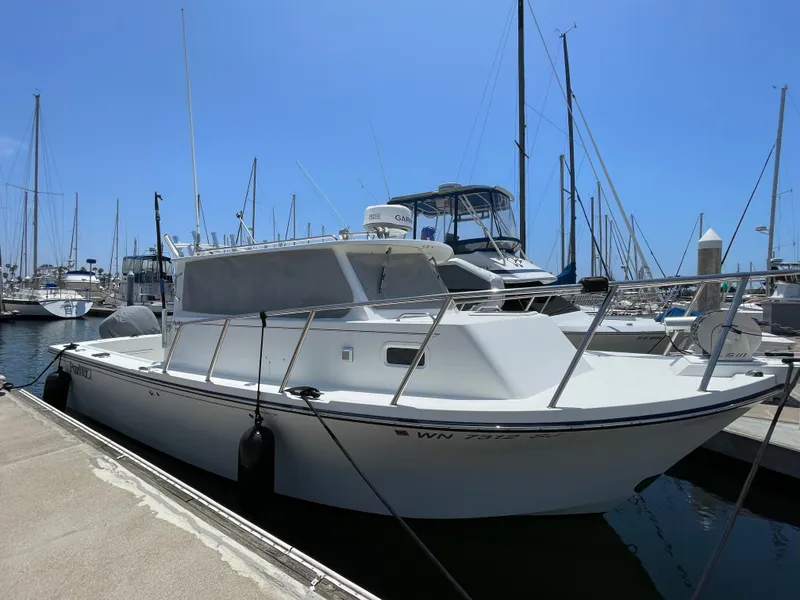 Slide: The Image of 2016 Parker 2530 Extended Sport Cabin boat docked at marina under clear blue sky. - 41