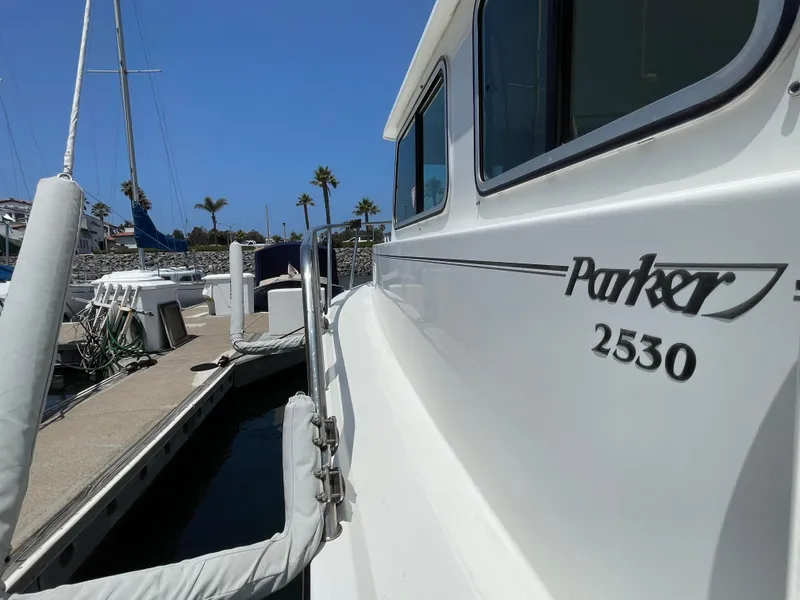 Slide: The Image of 2016 Parker 2530 Extended Sport Cabin docked at marina under clear blue sky. - 9