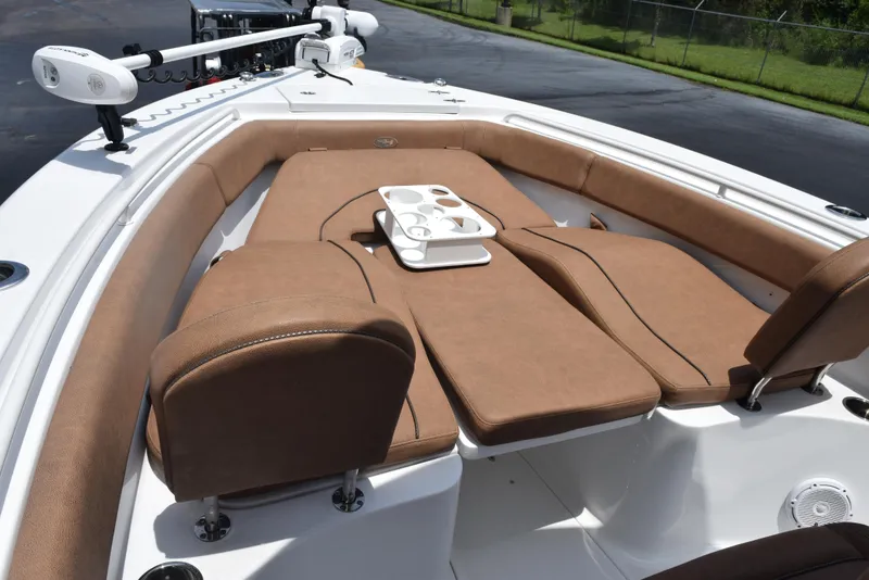 Slide: The Image of 2021 Sea Hunt Ultra 255 SE boat with tan cushioned seating and cup holders. - 13