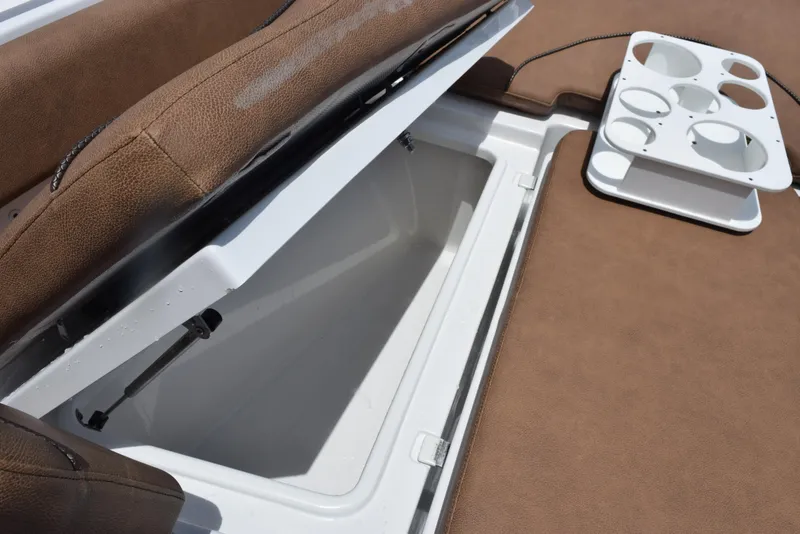 Slide: The Image of 2021 Sea Hunt Ultra 255 SE boat storage compartment with brown seating and cup holders. - 16