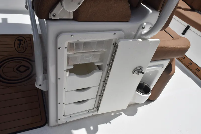 Slide: The Image of 2021 Sea Hunt Ultra 255 SE boat storage compartment with open door and seating. - 20