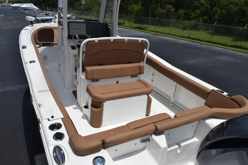 Slide: The Image of 2021 Sea Hunt Ultra 255 SE boat interior with tan seating and white deck. - 7
