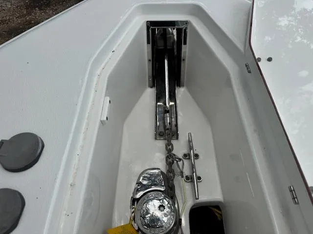 Slide: The Image of Anchor compartment of a 2016 Sea Hunt Gamefish 27 boat, featuring a winch and chain. - 17