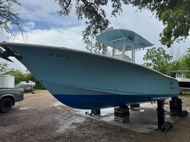 Slide: The Image of 2016 Sea Hunt Gamefish 27 boat on stands, light blue hull, outdoor setting. - 2