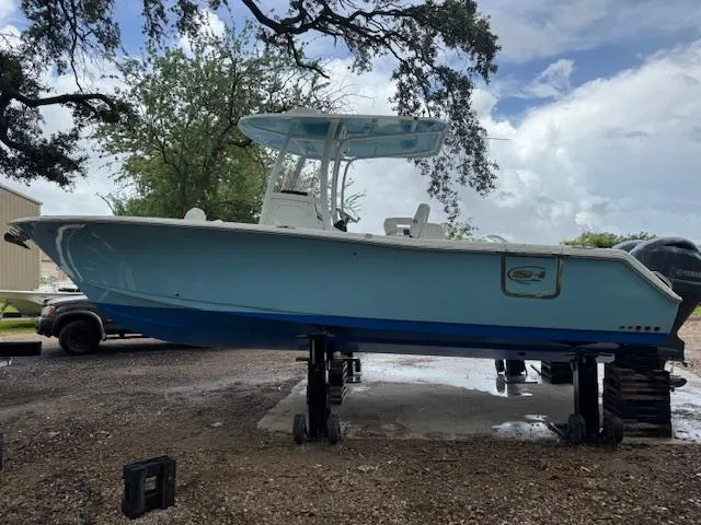 Slide: The Image of 2016 Sea Hunt Gamefish 27 boat on stands, light blue hull, outdoor setting. - 3