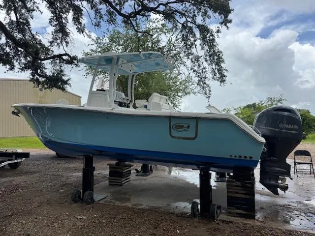 Slide: The Image of 2016 Sea Hunt Gamefish 27 boat on stands, under a tree, with Yamaha outboard motor. - 4