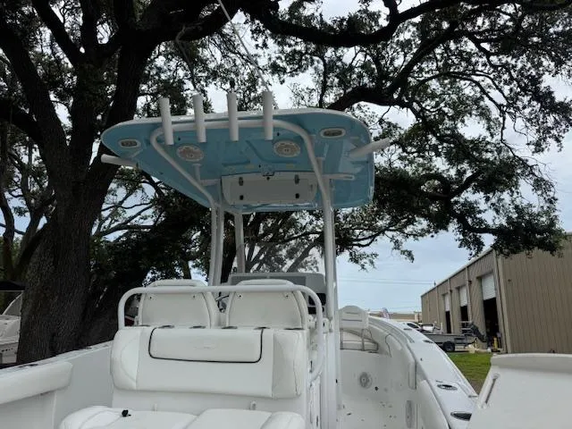 Slide: The Image of 2016 Sea Hunt Gamefish 27 boat with blue T-top, parked near trees and a building. - 9