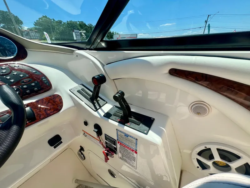 Slide: The Image of 2007 Sea Ray 290 SLX boat dashboard with controls and speaker, featuring wood accents. - 11
