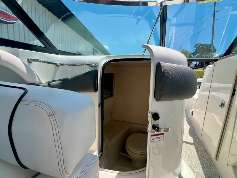 Slide: The Image of 2007 Sea Ray 290 SLX boat interior with open door revealing compact bathroom. - 15