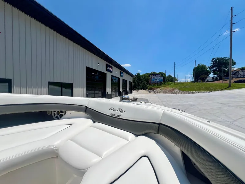 Slide: The Image of 2007 Sea Ray 290 SLX boat interior near a modern building under clear blue sky. - 17