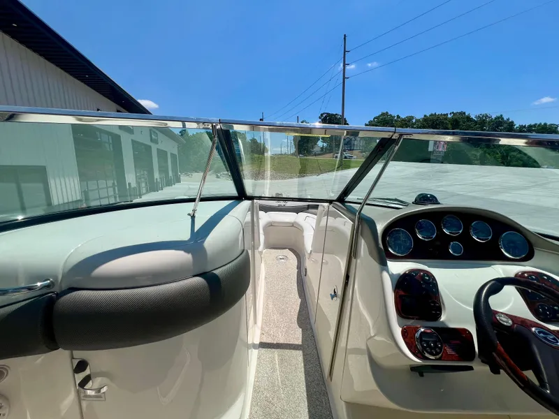 Slide: The Image of 2007 Sea Ray 290 SLX boat cockpit with dashboard and steering wheel, under clear blue sky. - 19