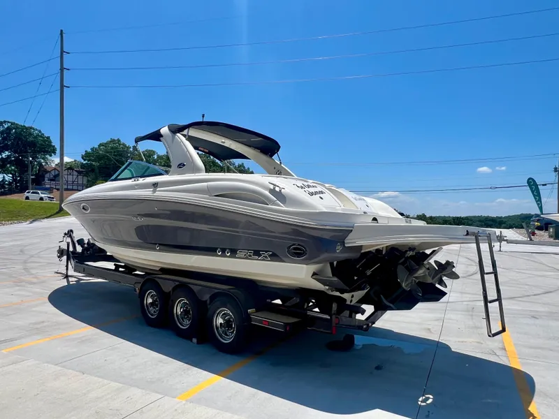 Slide: The Image of 2007 Sea Ray 290 SLX boat on trailer under clear blue sky. - 2