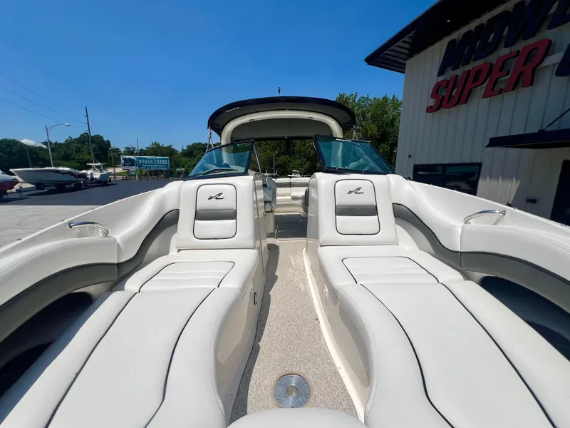 Slide: The Image of 2007 Sea Ray 290 SLX boat with white seating, parked outdoors near dealership. - 22