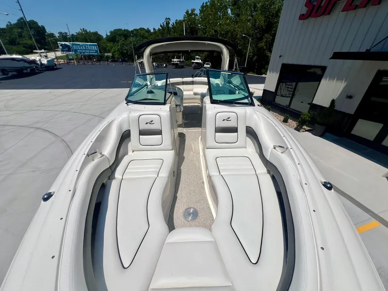 Slide: The Image of 2007 Sea Ray 290 SLX boat with spacious seating and sleek design, docked outdoors. - 23