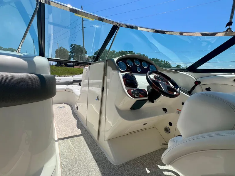 Slide: The Image of 2007 Sea Ray 290 SLX boat interior with steering wheel and dashboard under clear blue sky. - 8