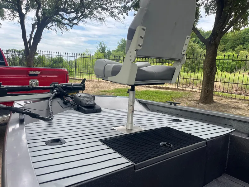 Slide: The Image of 2012 Alumacraft Pro 165 boat with swivel seat and trolling motor, parked near trees. - 10