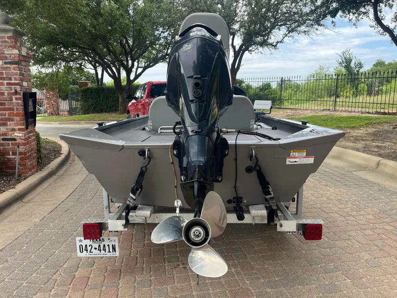 Slide: The Image of 2012 Alumacraft Pro 165 boat on trailer, rear view with motor, parked outdoors. - 12