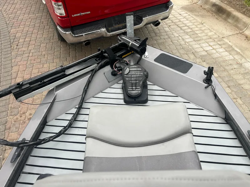 Slide: The Image of 2012 Alumacraft Pro 165 boat with trolling motor, parked near a red truck. - 21