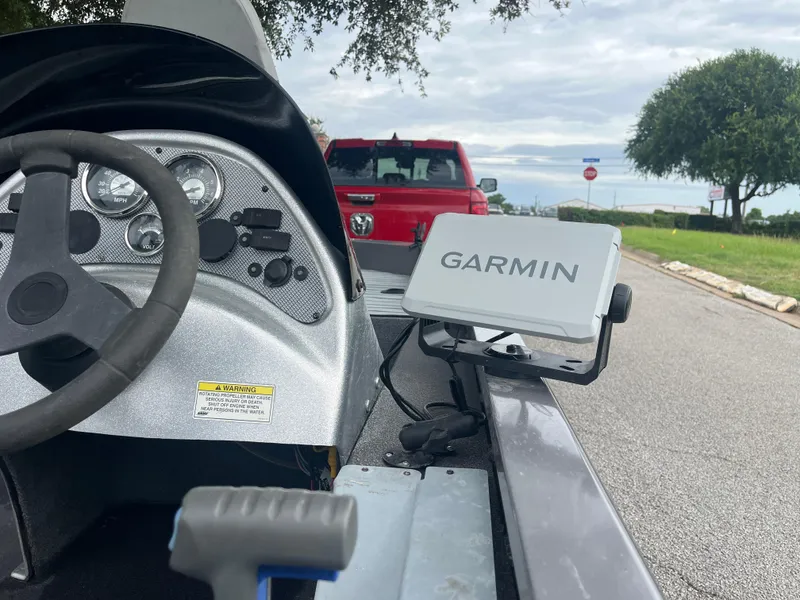 Slide: The Image of 2012 Alumacraft Pro 165 boat dashboard with Garmin GPS, parked near a red truck. - 33