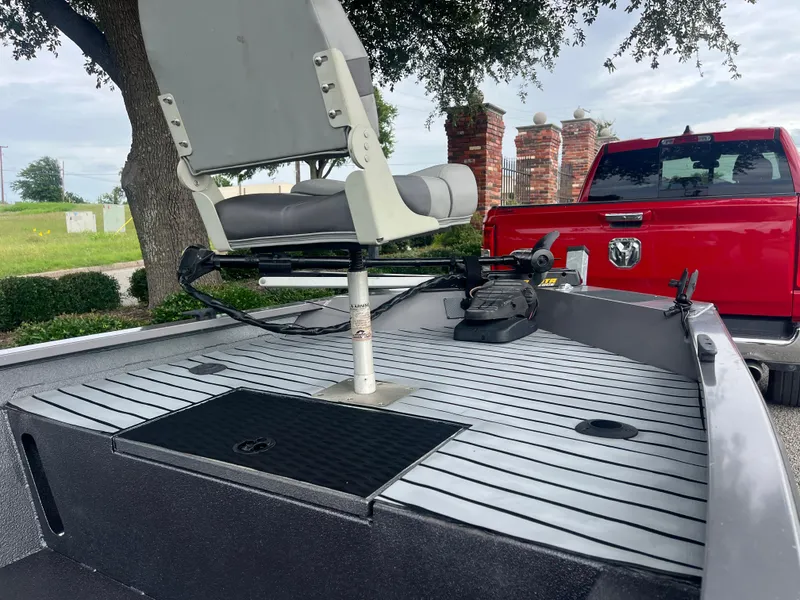 Slide: The Image of 2012 Alumacraft Pro 165 boat with seating, parked near a red truck. - 34