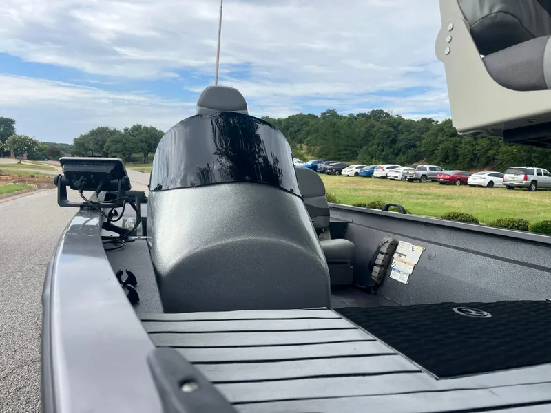 Slide: The Image of 2012 Alumacraft Pro 165 boat interior with seating and control panel, parked outdoors. - 35