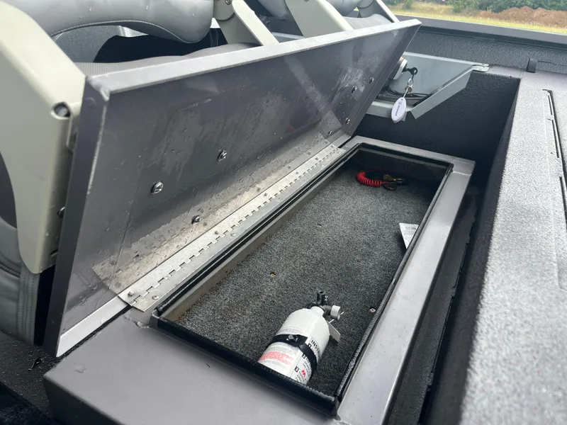 Slide: The Image of Open storage compartment in 2012 Alumacraft Pro 165 boat with fire extinguisher inside. - 38