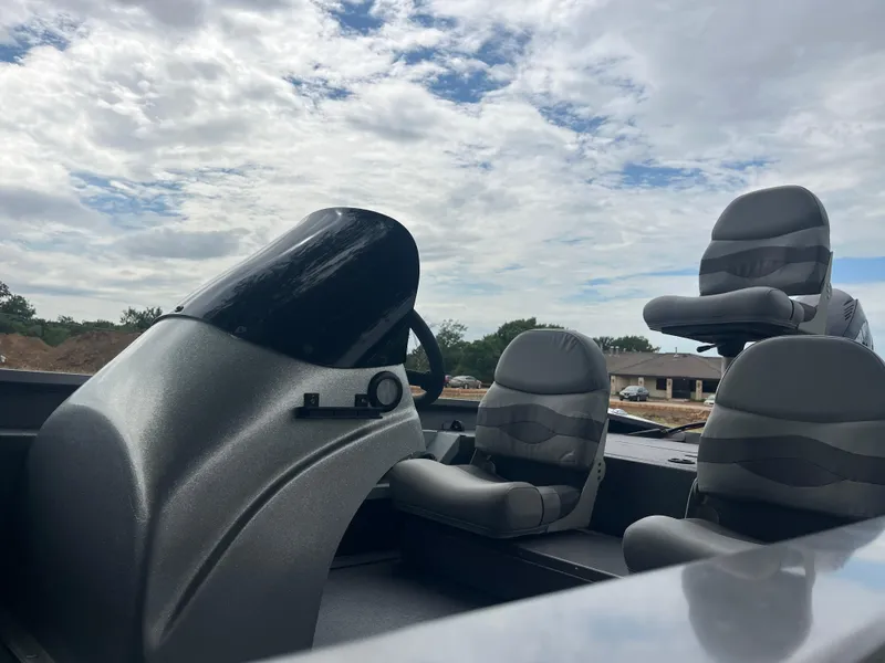 Slide: The Image of 2012 Alumacraft Pro 165 boat interior with seats and steering console under cloudy sky. - 39