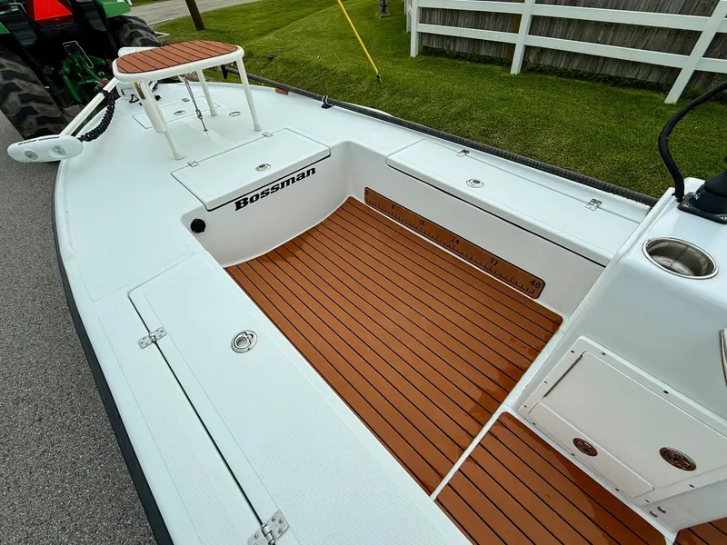 Slide: The Image of 2014 Bossman TailSpotter boat with wooden deck and white seating area. - 11