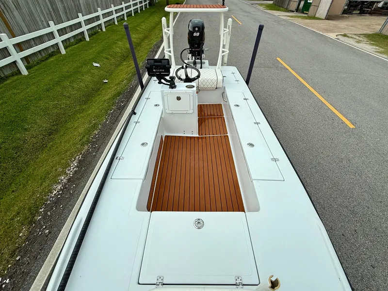 Slide: The Image of 2014 Bossman TailSpotter boat with wooden deck, parked on roadside. - 14