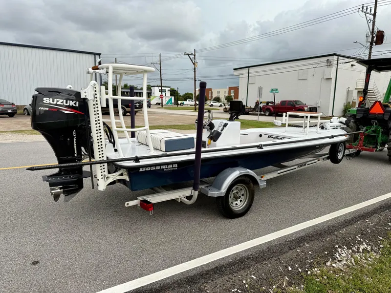 Slide: The Image of 2014 Bossman TailSpotter boat with Suzuki engine on a trailer, parked on a street. - 4
