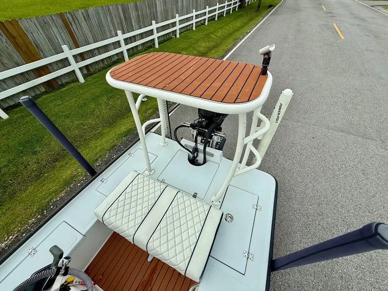 Slide: The Image of 2014 Bossman TailSpotter boat with elevated platform and cushioned seats on a road. - 7