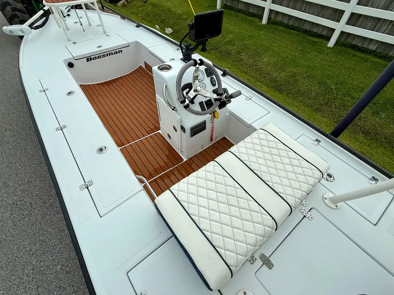 Slide: The Image of 2014 Bossman TailSpotter boat with white seating and wooden deck. - 9