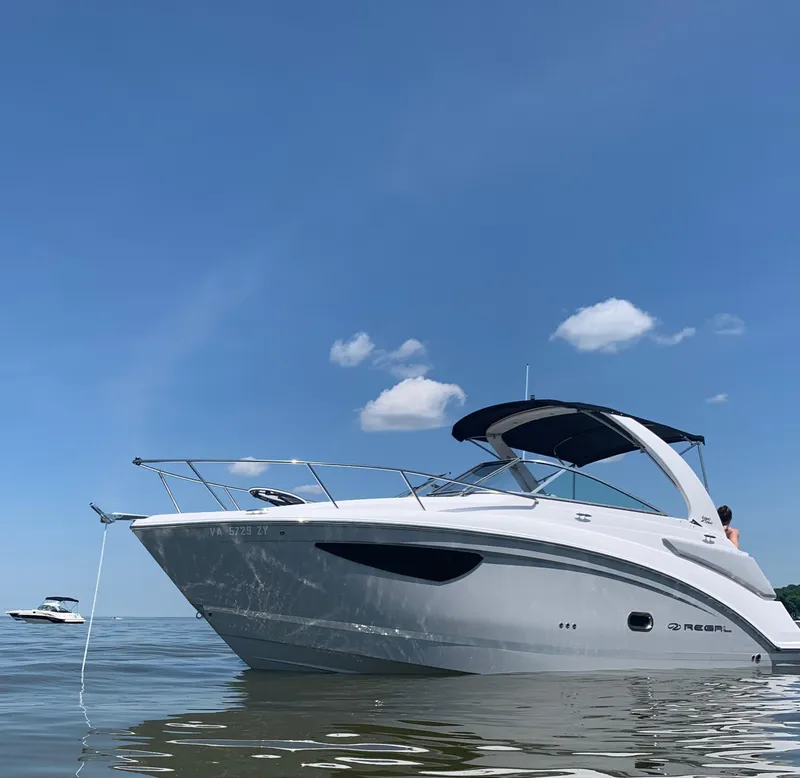 Slide: The Image of 2022 Regal 26 XO boat on calm water under clear blue sky. - 1