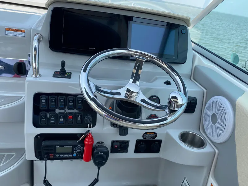 Slide: The Image of 2022 Regal 26 XO boat with canopy, docked on a calm lake. - 11