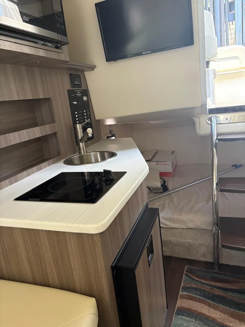 Slide: The Image of Interior of 2022 Regal 26 XO boat with kitchenette and TV. - 16