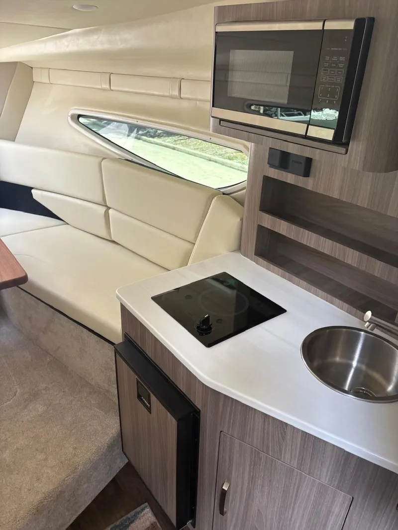 Slide: The Image of 2022 Regal 26 XO interior with kitchenette, microwave, and seating area. - 19