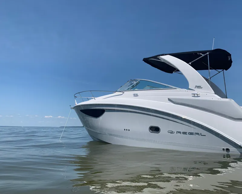 Slide: The Image of 2022 Regal 26 XO boat on calm water under clear blue sky. - 2