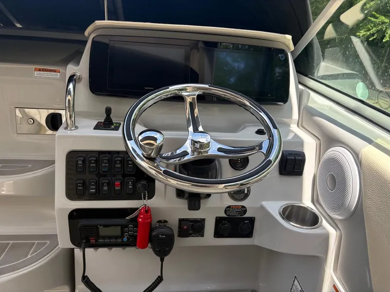Slide: The Image of 2022 Regal 26 XO boat helm with steering wheel, controls, and navigation screens. - 21