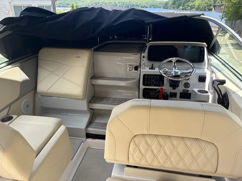 Slide: The Image of 2022 Regal 26 XO boat interior with helm, beige seating, and lake view. - 23