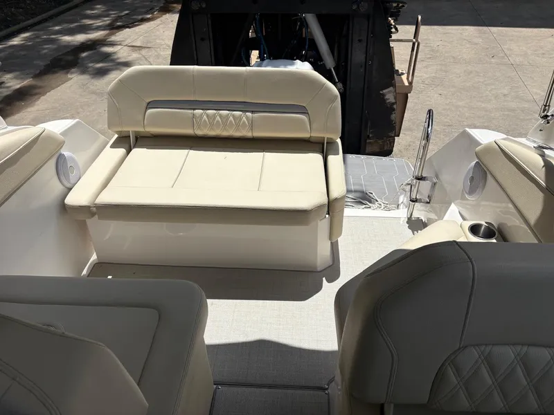 Slide: The Image of 2022 Regal 26 XO boat interior with beige seating and cup holders. - 24