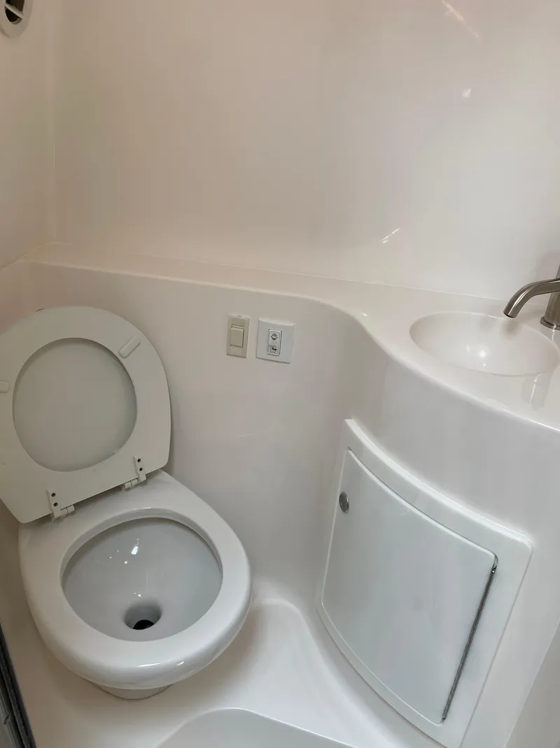 Slide: The Image of 2022 Regal 26 XO boat docked at a marina, surrounded by water and greenery. - 4