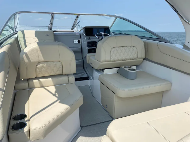 Slide: The Image of 2022 Regal 26 XO boat interior with steering wheel and dashboard, overlooking calm waters. - 8