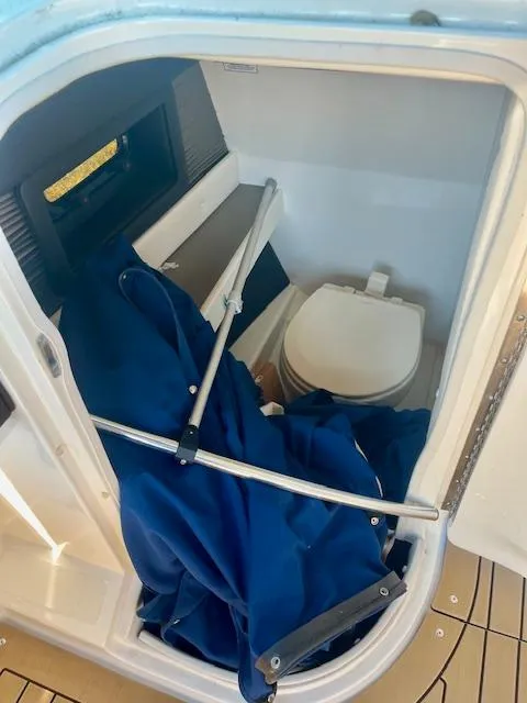 Slide: The Image of 2020 Sea Ray SLX 250 boat interior with compact toilet and storage area. - 10