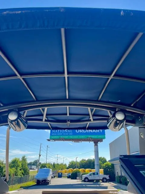 Slide: The Image of 2020 Sea Ray SLX 250 boat canopy with speakers, outdoor setting, clear blue sky. - 13