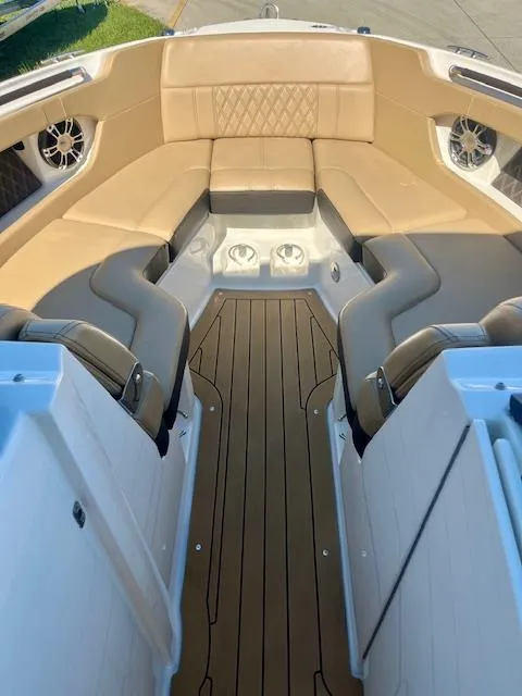 Slide: The Image of 2020 Sea Ray SLX 250 boat interior with tan seating and wood-style flooring. - 8